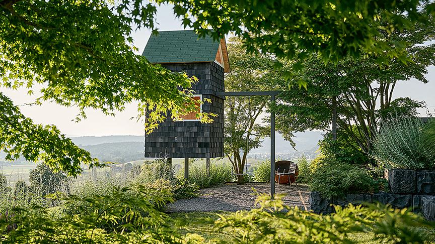 Schindelverkleidetes Baumhaus, welches die Höhendifferenz nutzt. (Gartenkultur AG)