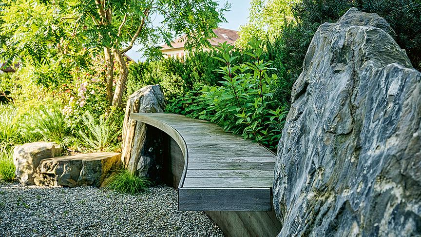 Geschwungene Holzmöbel ergänzen hier das naturnahe Konzept (Gartenkultur AG)