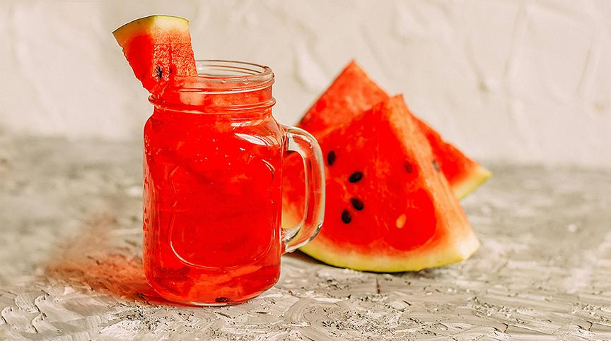 © Foto: Unsplash Rotes Getränk in Henkelglas garnitert und dekoriert mit Wassermelonenscheiben.