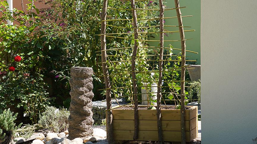 Die Gärtnerinnen der Garten Garten Tulln bauen ein bewachsenes Spalier aus Schnittgut.