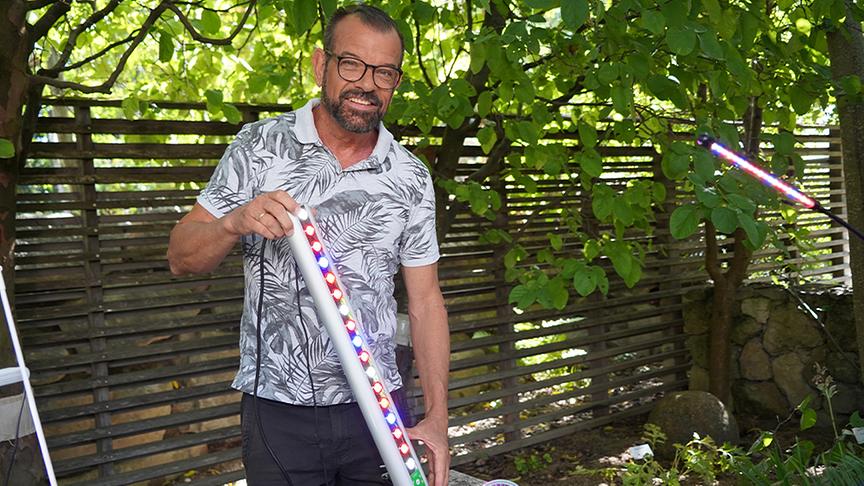 Karl Ploberger hält eine LED-Leiste fpr Pflanzen in der Hand.