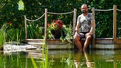 Karl Ploberger hält die Füße in einen Schwimmteich