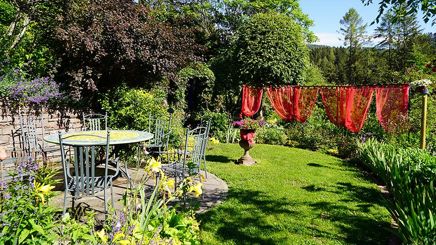 Eine idyllischen Sitzgelegenheit darf in so einem gemütlichen Garten natürlich nicht fehlen.