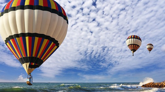 © Colourbox Balloons fahren über das Meer.