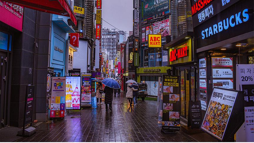 © Foto: Unsplash Shoppingstraße mit vielen bunten Schildern und Neonreklamen links und rechts.