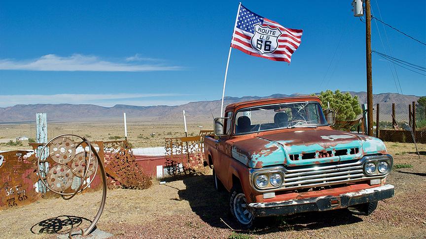 © Unsplash Ein alter rostiger Pick-Up mit Amerika-Flagge.