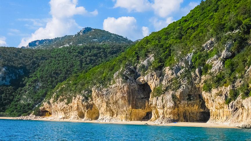 Der kleine, unberührte Strand Cala Luna liegt im  Naturschutzgebiet Gennargentu. Die abgelegene Bucht ist geschützt durch steile Felswände, deren viele kleine Grotten vor der Sonne schützen.