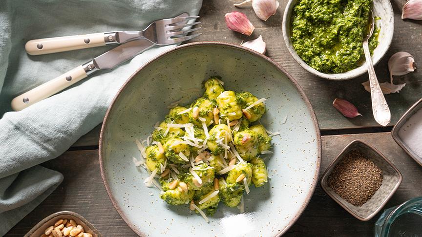 © © Andrea Natschke-Hofmann/Jan Thorbecke Verlag Gnocchi mit Grünkohl-Pesto auf einem Tisch angerichtet mit den rohen Zutaten darumherum.