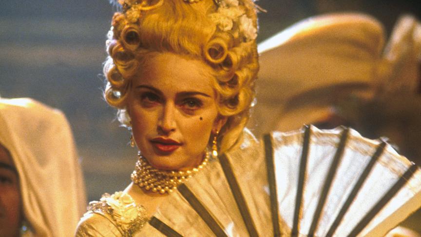 Madonna in kaiserlicher Garderobe mit passendem Pudermake-up, weißer Perücke und mit Fächer.