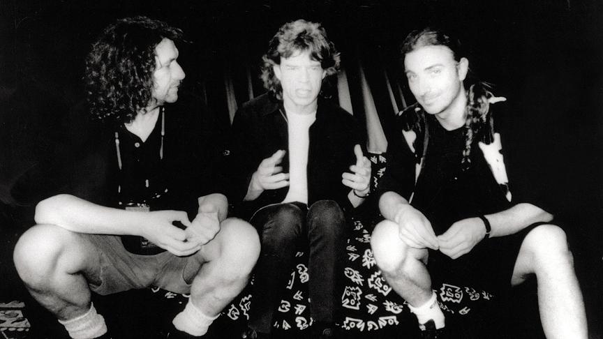 Schwarz-weiß Aufnahme von Hannes Rossacher, Mick Jagger und Rudi Dolezal auf einem Sofa sitzend.
