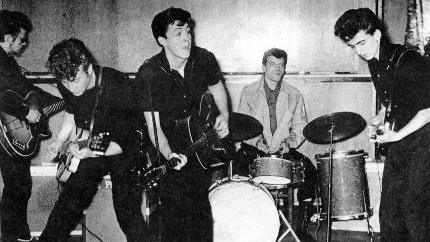 Schlechte schwarz-weiß Aufnahme der Beatles bei einem Auftritt.