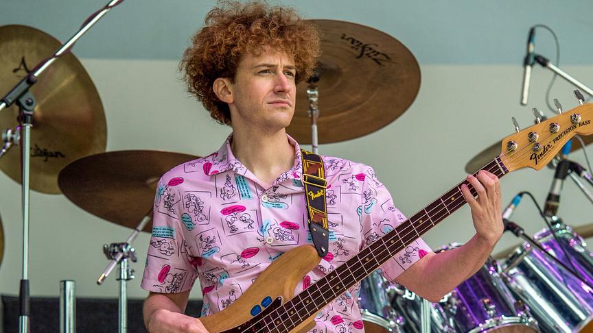 Mann spielt Gitarre auf einer Bühne