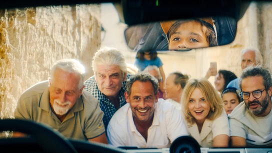 © Foto: ORF/ProSieben/LEONINE Studios Eine Gruppe Menschen helfen zusammen, um eine Auto durch eine schmale Gasse zu schieben. Sie sehen dabei sichtlich erfreut angesichts der Zusammenarbeit aus. Die Szene ist aus dem Auto heraus fotografiert, im Rückspiegel sieht man das Gesicht eines Jungen.