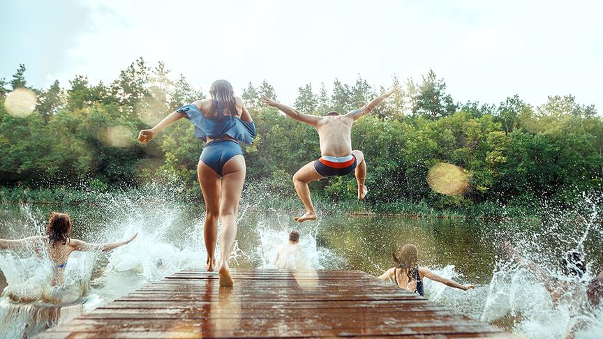 © Foto: Colourbox Eine Frau und ein Mann springen vom Steg in den See.