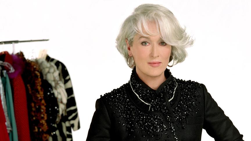 Frau mit kurzen, grauen Haaren in aufrechter Pose