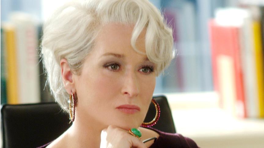 Frau mit kurzen grauen Augen  blickt streng