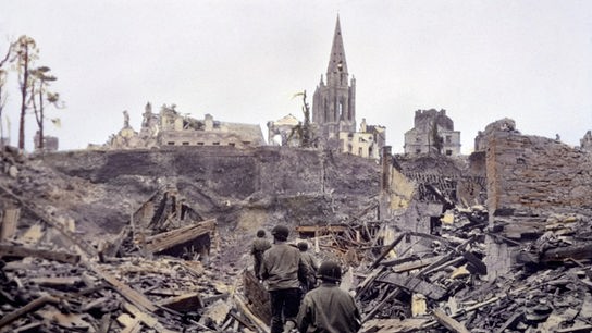 Im Bild: Eine US-Infanteriepatrouille bahnt sich einen Weg durch die Ruinen von Saint Lô. Die französische Stadt wird im Zweiten Weltkrieg zu 95 Prozent zerstört.
