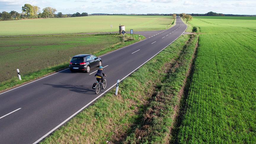 Im Bild: Experiment in Kremmen-Linum: Kristin Garner testet, wie gefährlich Überholvorgänge auf Landstraßen ohne Radweg sind.