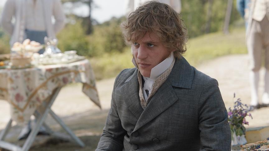 Ein Mann sitzt und blickt von unter unauffällig nach oben.