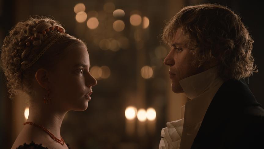 Eine Frau und ein Mann blicken sich bei Kerzenlicht tief in die Augen.