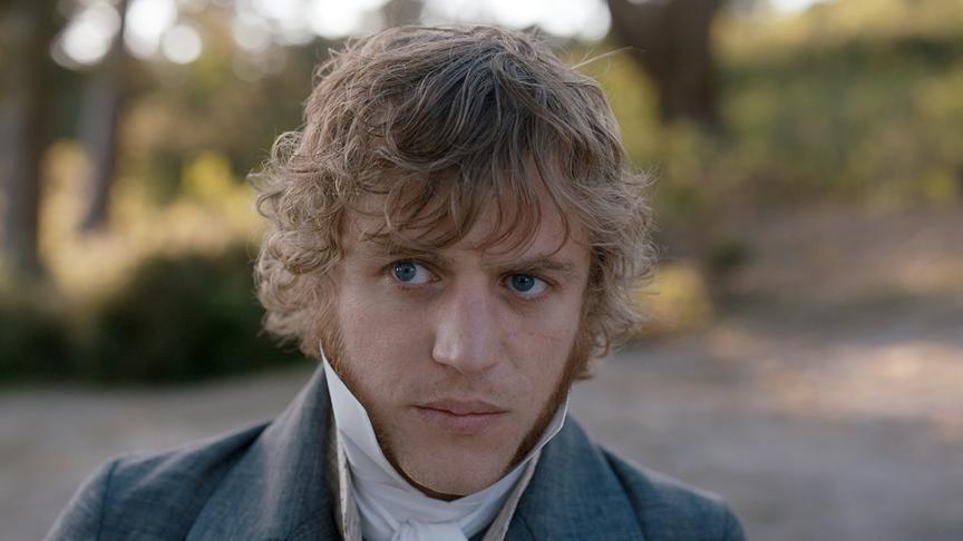 Ein Mann blickt nach Links mit ernstem Gesichtsausdruck.