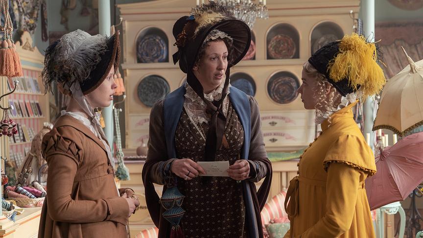 Drei Frauen stehen in einem Laden und führen ein Gespräch miteinander.