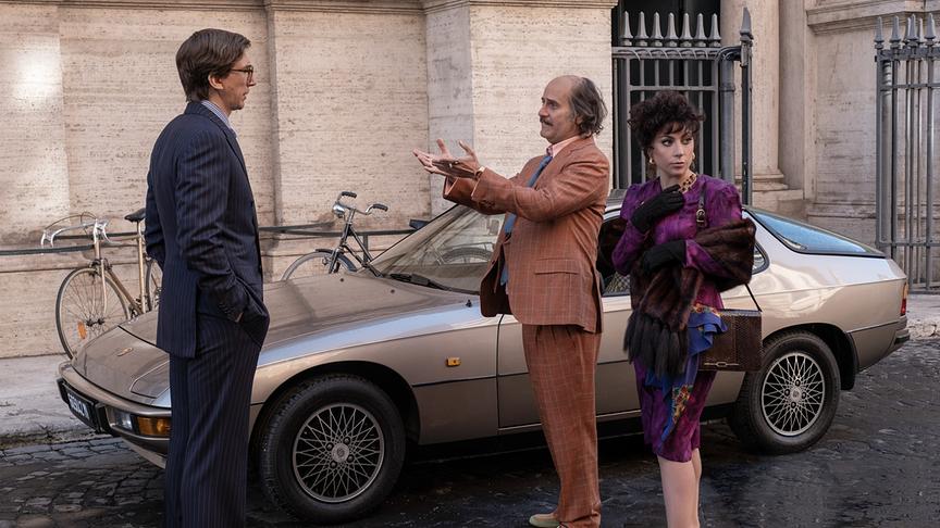 Zwei Männer und eine Frau neben einem Auto stehend