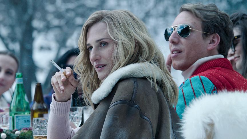 Mehrere Personen in Winterkleidung um einen Tisch mit verschiedenen Getränken im Freien