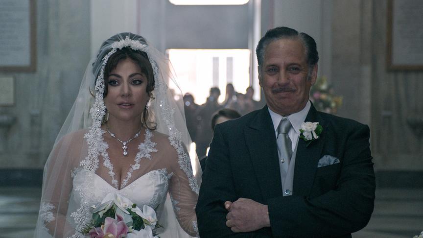 Ein Mann geleitet eine Braut im weißen Kleid 