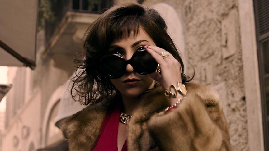 Frau mit Pelzmantel blickt über ihre große Sonnenbrille hinweg