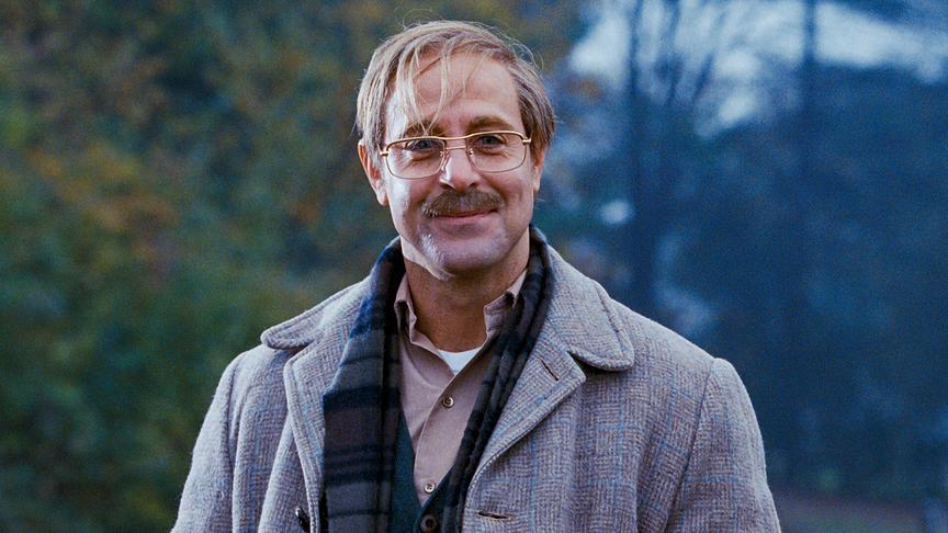 Mann mit Schnauzbart draußen.