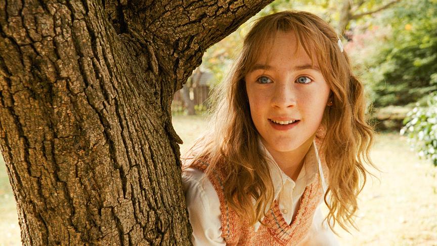 Mädchen gelehnt an einen Baumstamm.