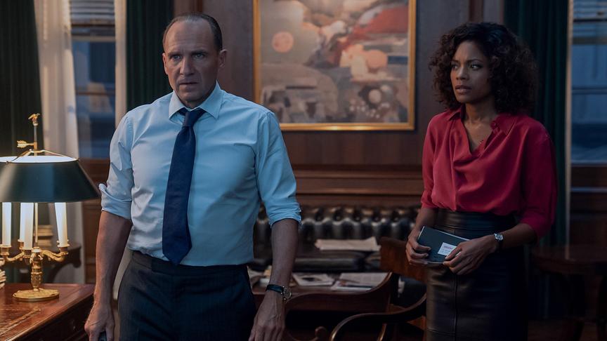 Ein Mann und eine Frau mit erschrockenen Gesichtern stehen in einem Büro.