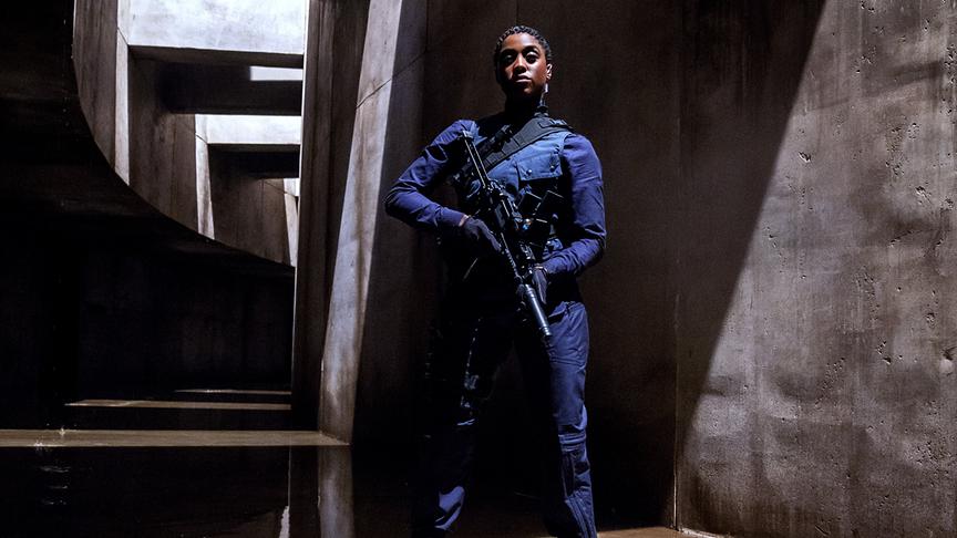 Frau im blauen Overall mit Waffe in den Händen.