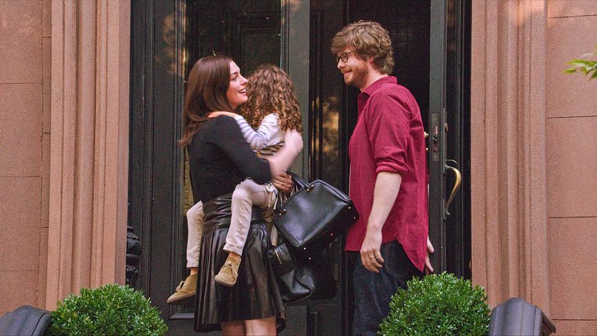 Eine Frau trägt ein kleines Mädchen in den Armen, ihr gegenüber steht ein Mann