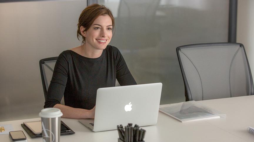 Eine Frau mit Laptop an einem Tisch