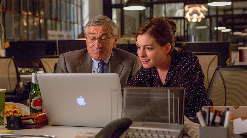 Ein Mann und eine Frau schauen auf einen Laptop