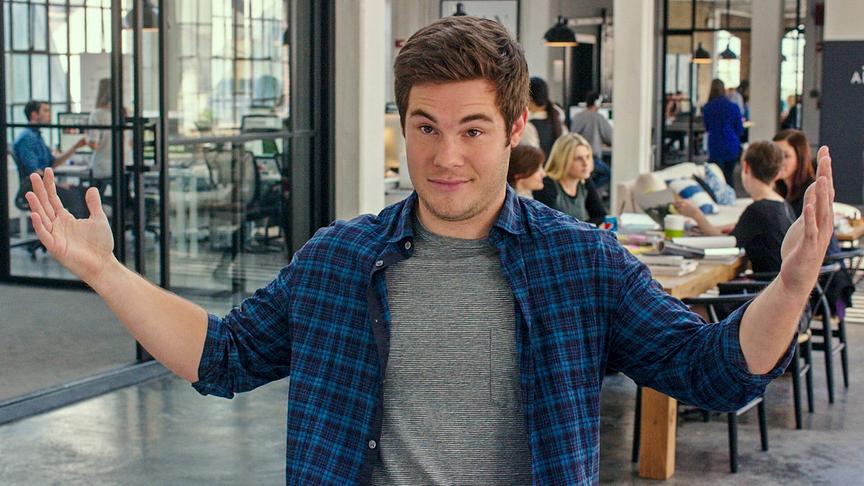 Ein Mann mit leicht erhobenen Armen und hochgezogenen Augenbrauen in einem Büro