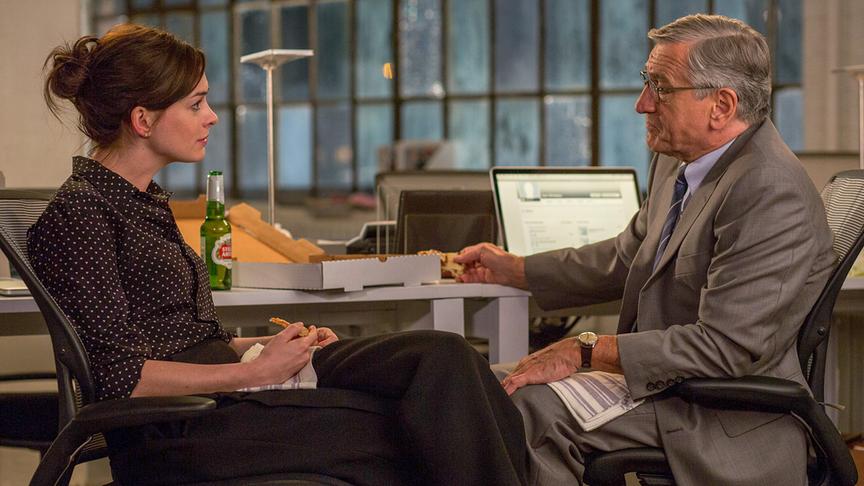 Eine Frau und ein Mann sitzen sich gegenüber, zwischen ihnen ein Pizzakarton