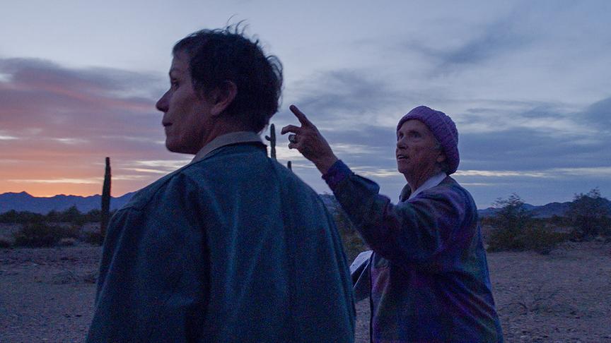 Eine Frau zeigt einer anderen etwas am Himmel.