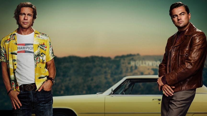 Zwei Männer lehnen sich an die Ränder des Bildfokus, im Hintergrund ein Auto und der Hollywood-Schriftzug