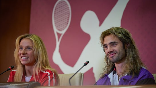 © Foto: ORF/Bravado Media/MarVista Entertainment/Umberto Poto Eine Frau und ein Mann an einem Tisch mit Mikrofone. Im Hintergrund eine Wand mit weißer Tennisspielershilouette.