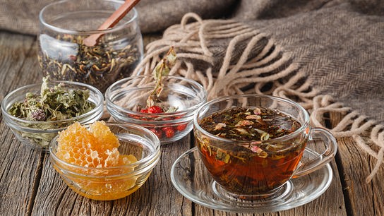 Kräuterteeemischungen und Honigwabe in Schüsseln