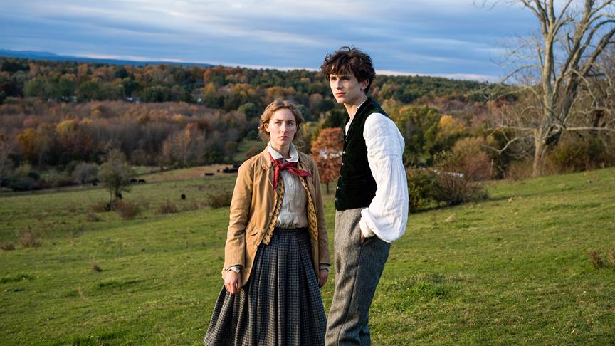 Ein Junge und ein Mädchen stehen auf einem Hügel in der Natur und blicken in die gleiche Richtung.