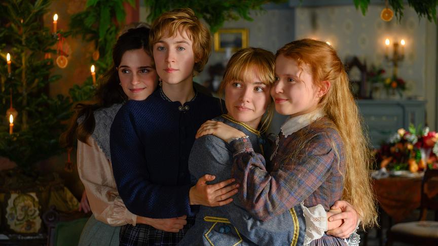 Vier Mädchen drängen sich lächelnd aneinander und blicken alle in die gleiche Richtung.