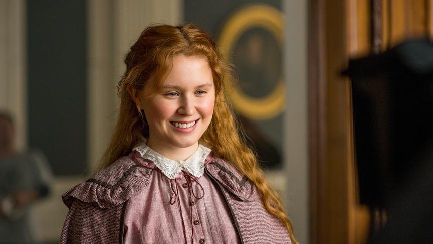 Ein Mädchen blickt lächelnd nach unten.