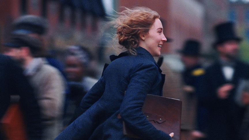 Ein Mädchen rennt lächelnd mit wehenden Locken und einer Mappe in der Hand.