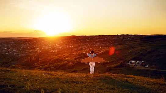 © Colourbox Kind mit Papierflügeln blickt auf den Horizont.