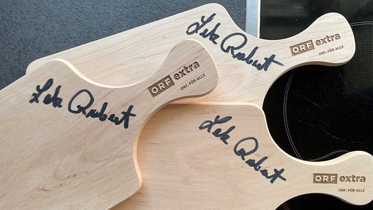 © Foto: ORF extra Schneidbrett aus Holz, signiert von ORF-Koch Robert Letz