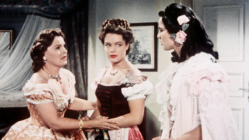 Im Bild: Ludovika (Magda Schneider, li.) bereitet ihre älteste Tochter Helene (Uta Franz, re.), genannt Nene, auf das Treffen mit dem österreichischen Kaiser vor. Die stürmische, junge Sissi (Romy Schneider) stört da nur.